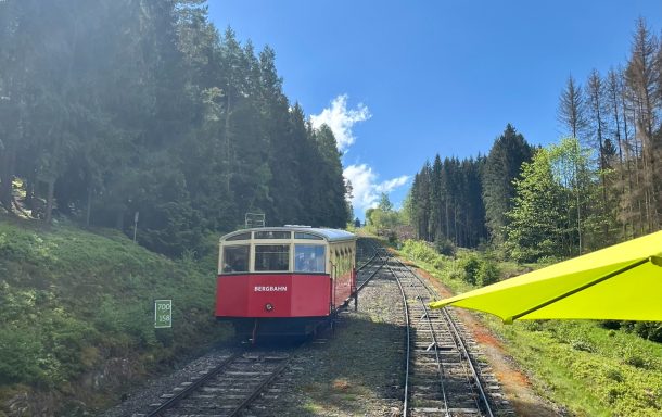 Thüringer Bergbahn (ehem. Oberweißbacher Bergbahn) Zug auf einer steilen Schiene, umgeben von Bäumen und blauem Himmel.