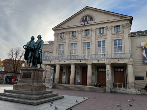 Weimar Historisches Theatergebäude mit einer Statue von zwei Männern im Vordergrund.