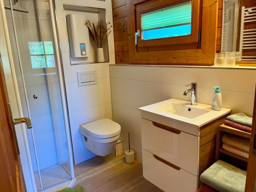 Bad Modernes Badezimmer mit Dusche, Waschbecken und Holzdetails. Helle Farbgestaltung.