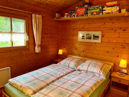 Schlafzimmer Gemütliches Schlafzimmer in einem Holzhaus mit einem Doppelbett und Regale mit Büchern.